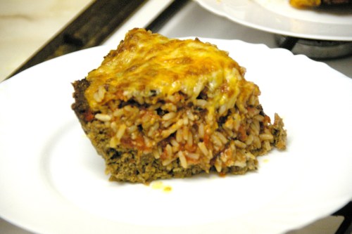 A slice of cheesy meat-and-rice pie on a plate